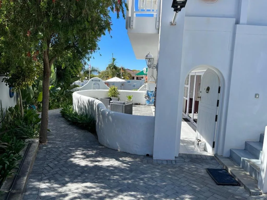 White-walled entrance courtyard with curved walls and paved driveway