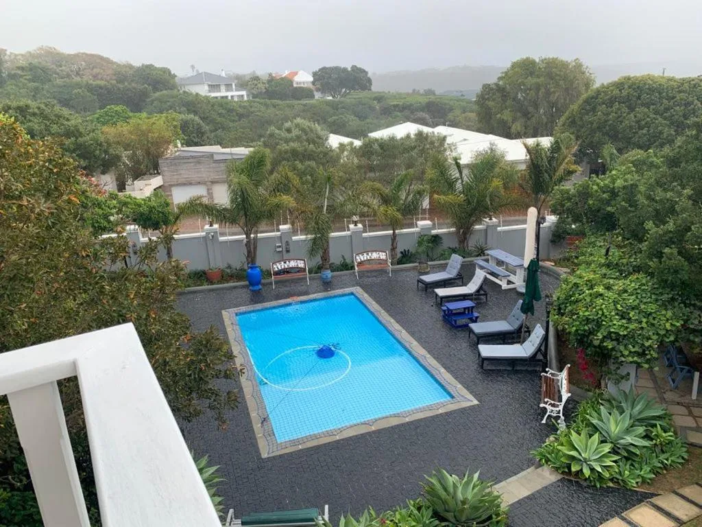 Rectangular swimming pool with loungers overlooking lush green mountains