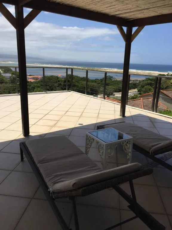 Covered deck with loungers overlooking lagoon and coastal views