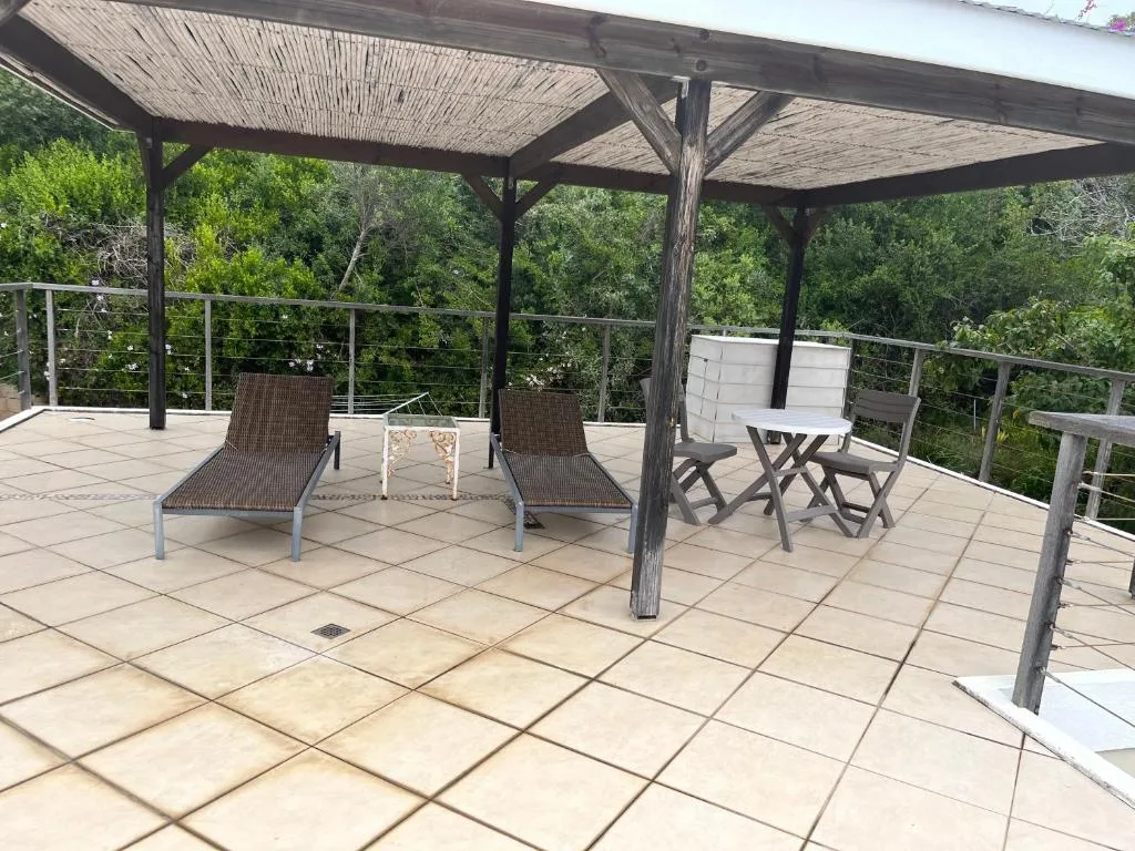 Shaded patio with loungers and seating overlooking lush vegetation