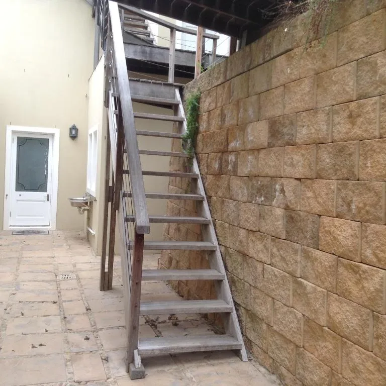 Exterior staircase and entrance alley with stone wall and door