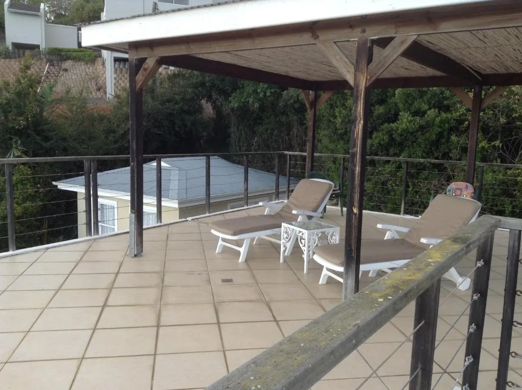 Covered wooden pergola deck with loungers and forest views