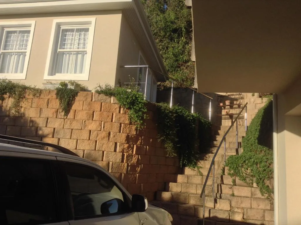 Stone steps and brick walls lead to property entrance with climbing ivy