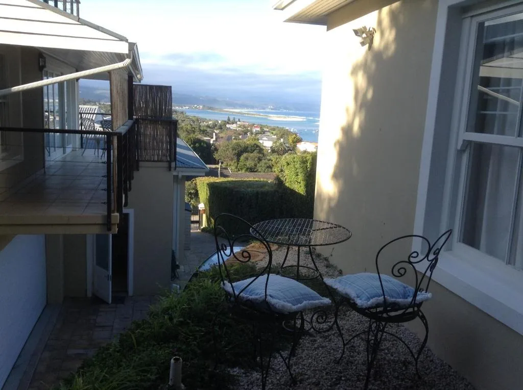 Coastal vista of Plettenberg Bay lagoon and mountains from garden seating area