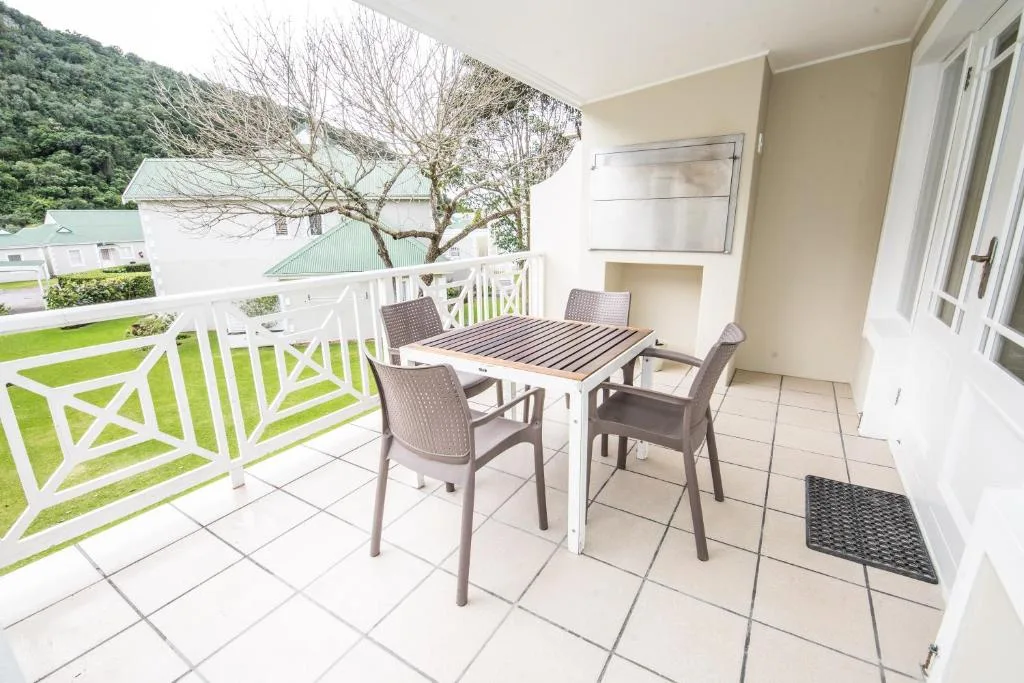 Outdoor patio with dining table, chairs, and scenic mountain views beyond