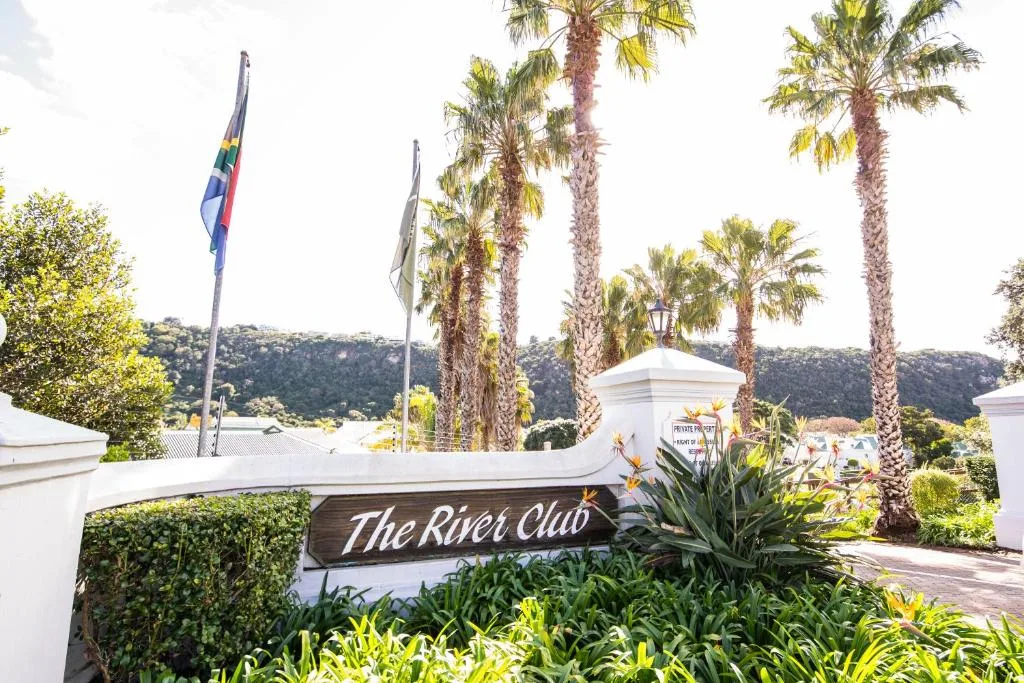 The River Club entrance sign with palm trees and manicured gardens