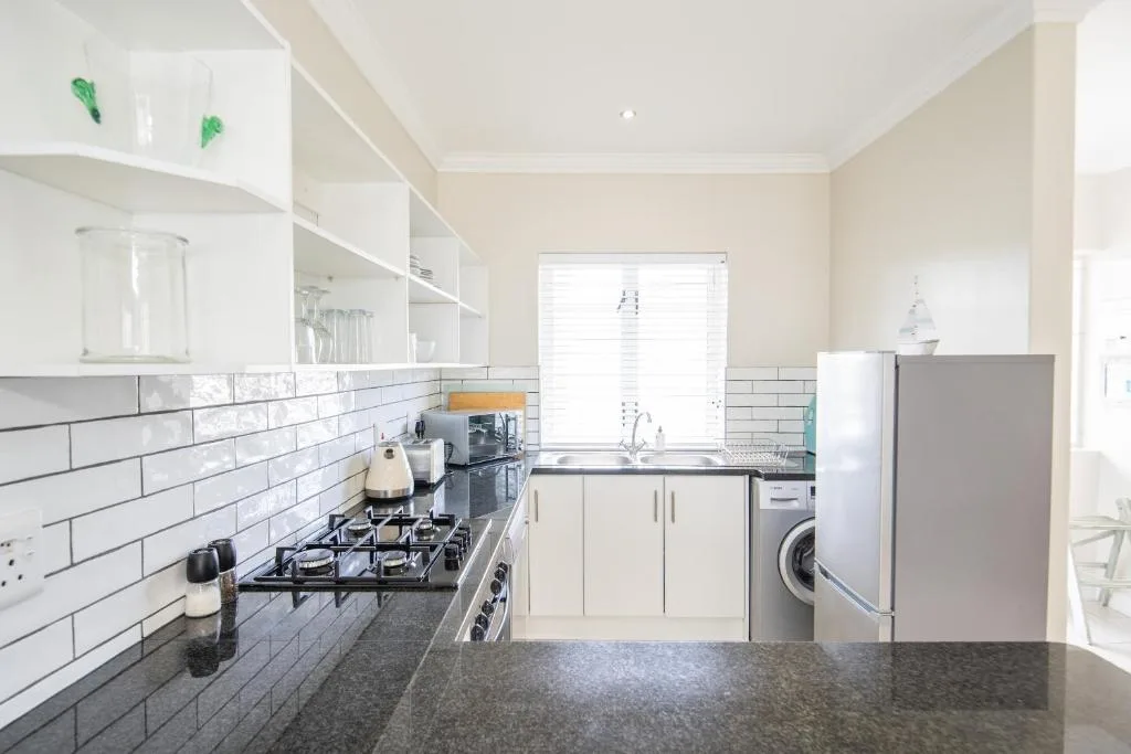 Modern kitchen with white cabinetry, subway tile backsplash, and stainless steel appliances