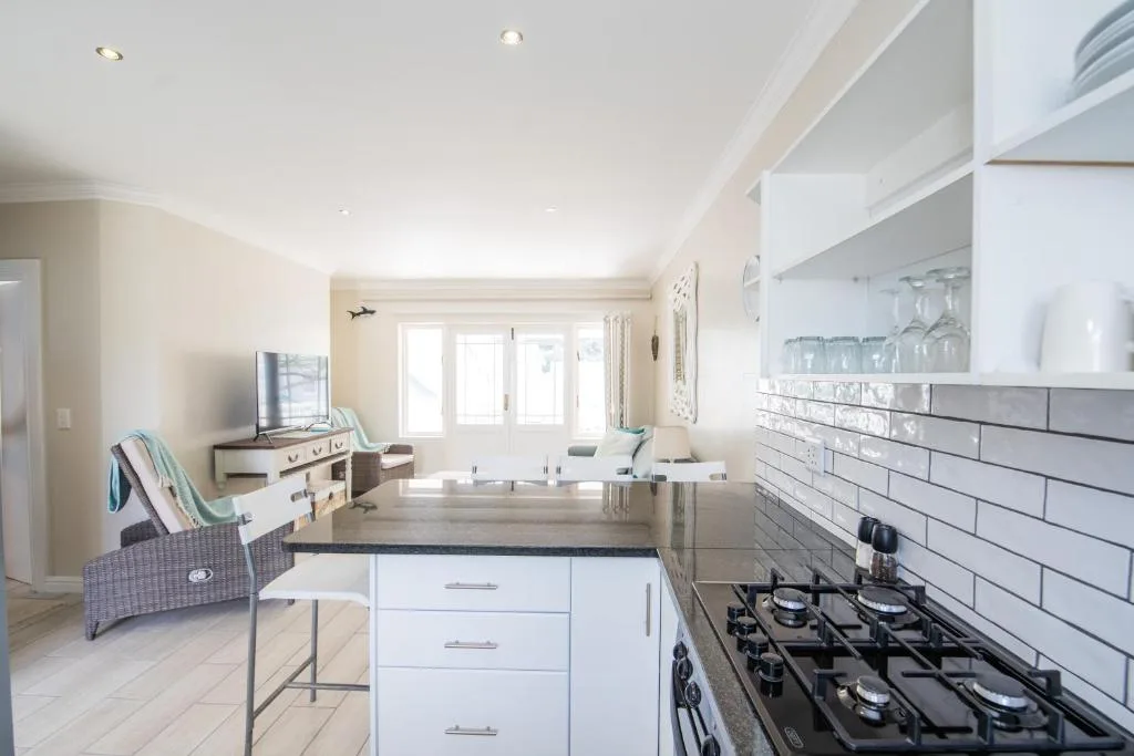 Modern kitchen with white cabinetry, black gas stove, and subway tile backsplash