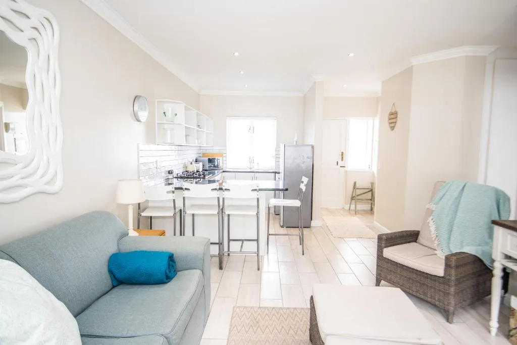 Open-plan lounge with gray sofa overlooking kitchen and dining area