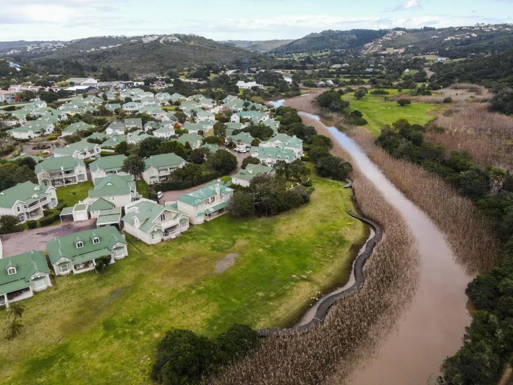 Aerial view of riverside property with green roofs and winding river bend