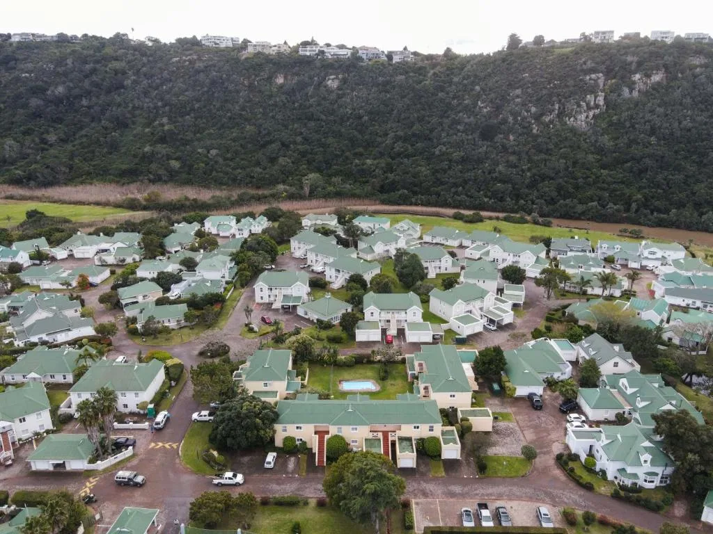 Aerial view of Eleven River Club resort with green roofs and forested cliffs