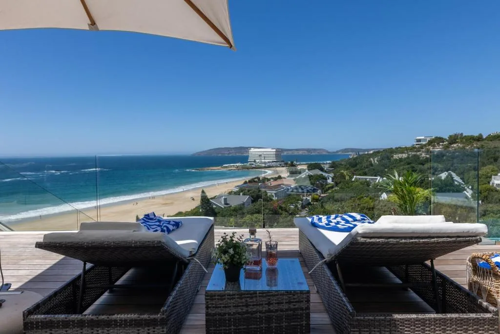 Outdoor deck with lounge chairs overlooking pristine beach and ocean