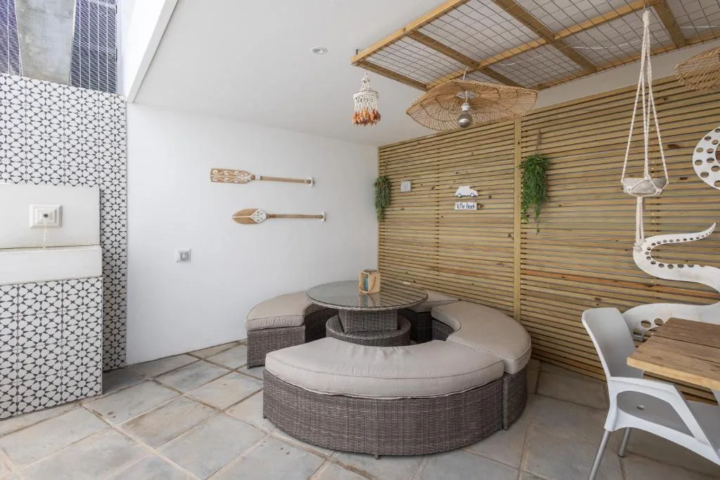 Outdoor seating area with curved wicker furniture and wooden slat wall