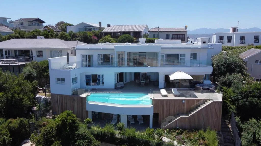 Modern white villa with curved pool deck and mountain views, Plettenberg Bay