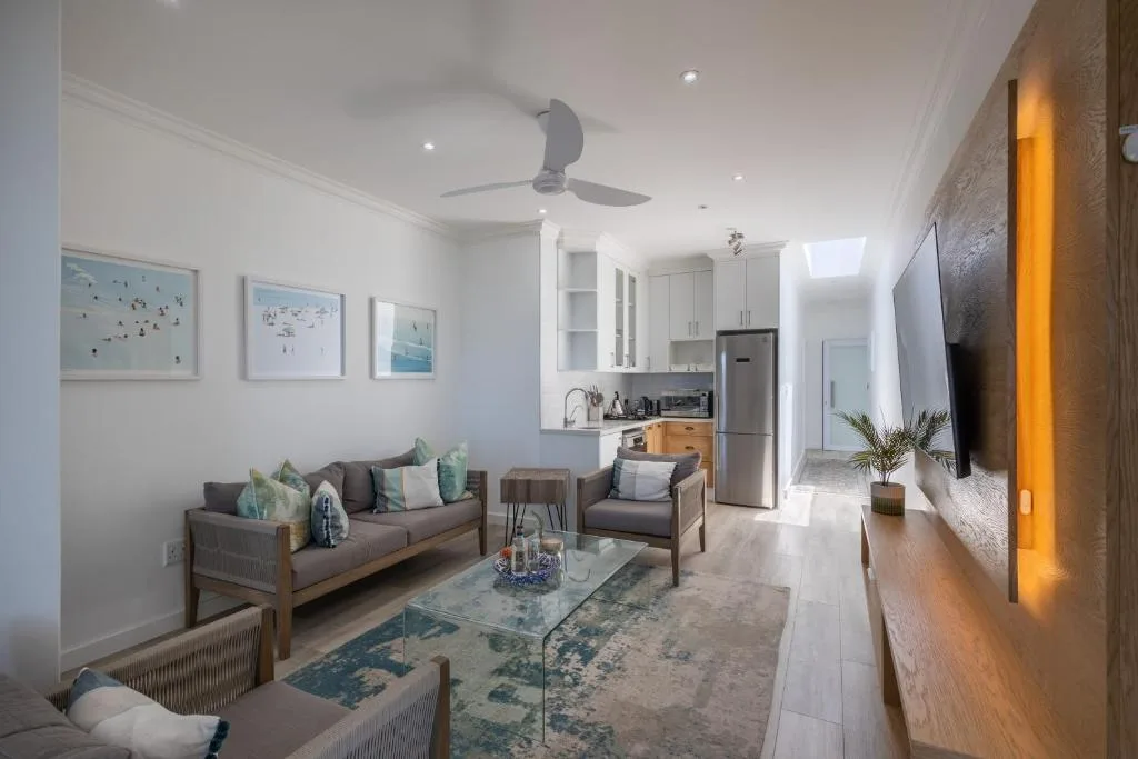 Modern lounge with gray sofa, armchair, and ocean-themed wall art