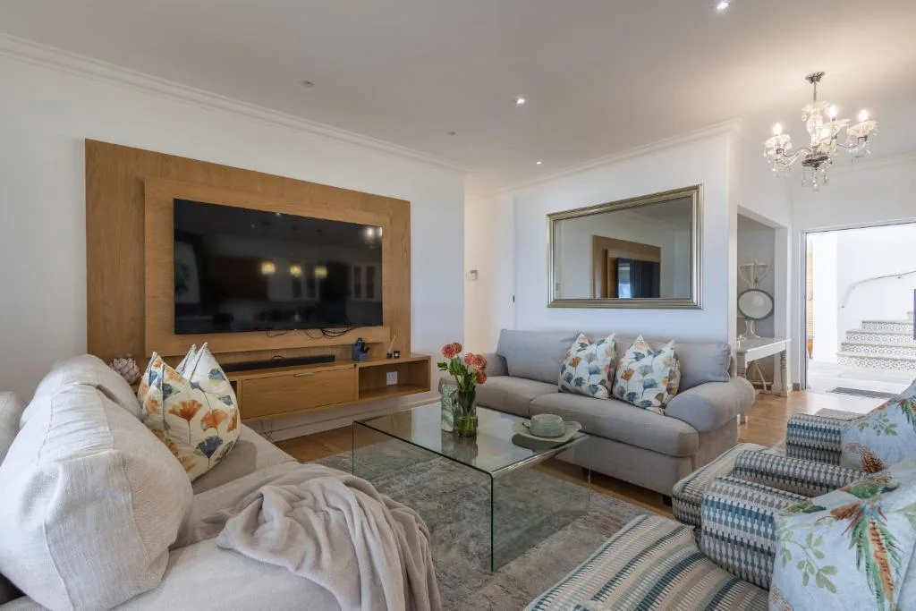 Spacious lounge with gray sofa, fireplace, TV, and elegant decor