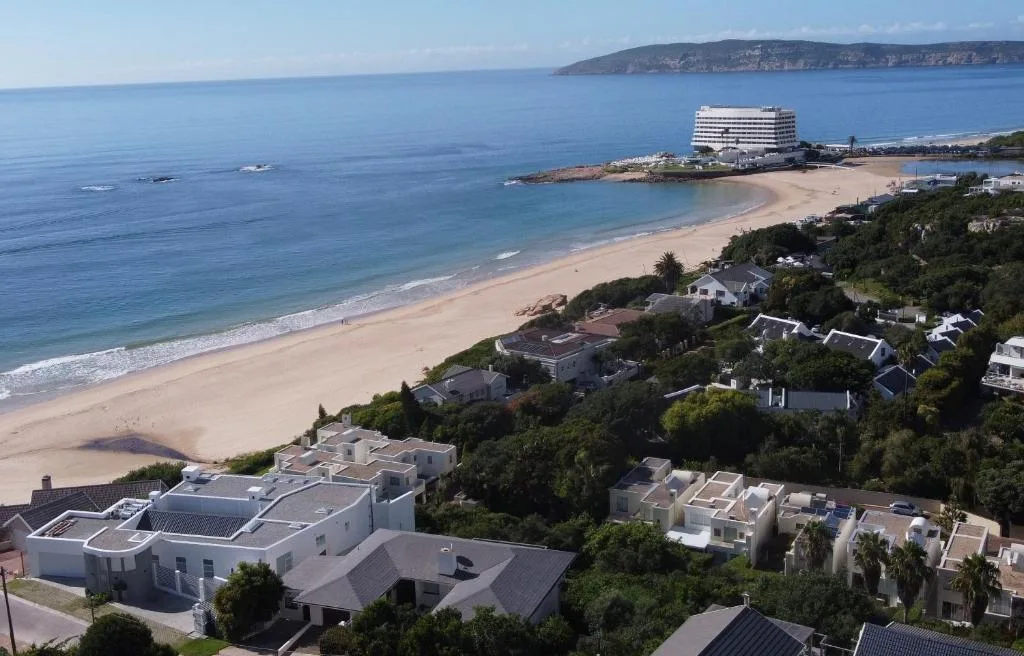 Expansive coastal view of pristine beach and sparkling ocean from elevated vantage point