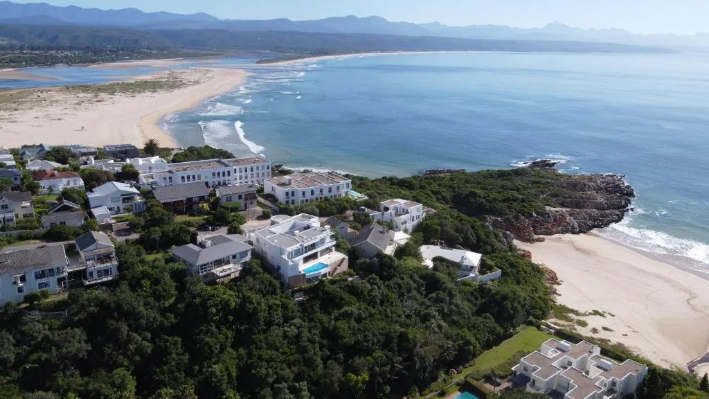 Aerial view of beachfront properties overlooking pristine sandy beach and blue ocean