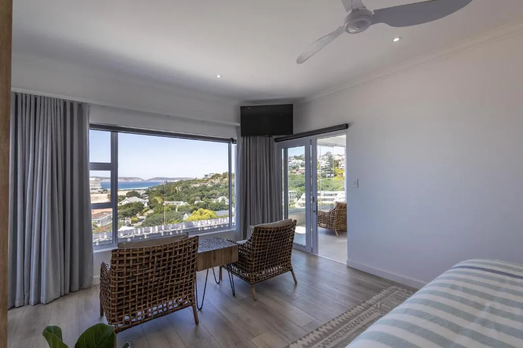 Scenic coastal and mountain views from bedroom with floor-to-ceiling windows