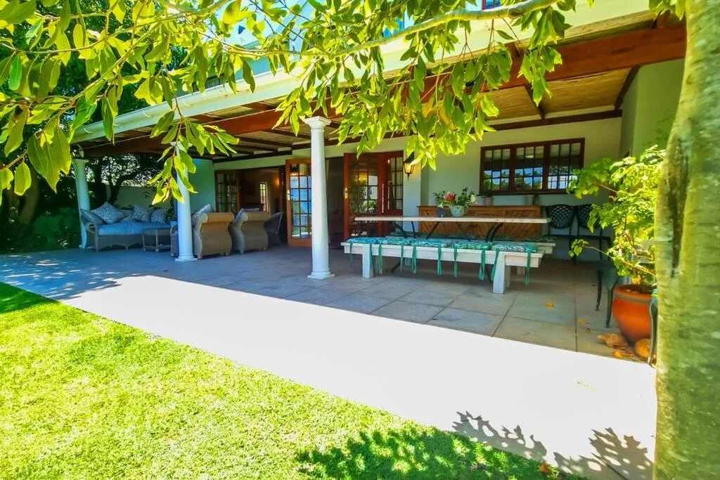 Covered patio with foosball table, seating, and lush green vine canopy