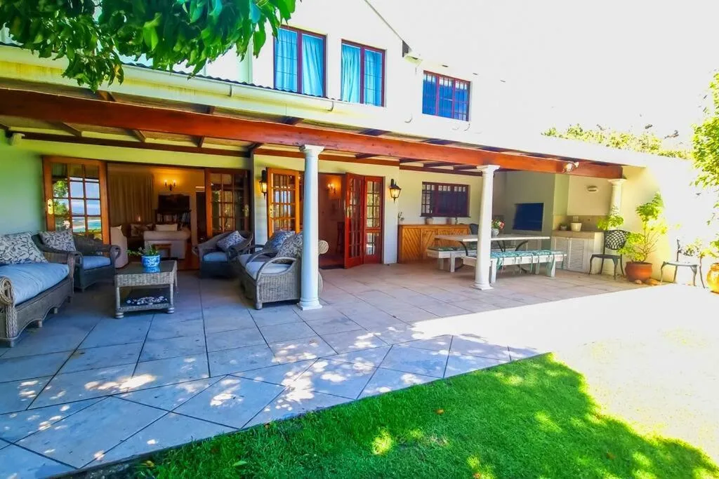 Spacious covered patio with seating, dining area, and garden views