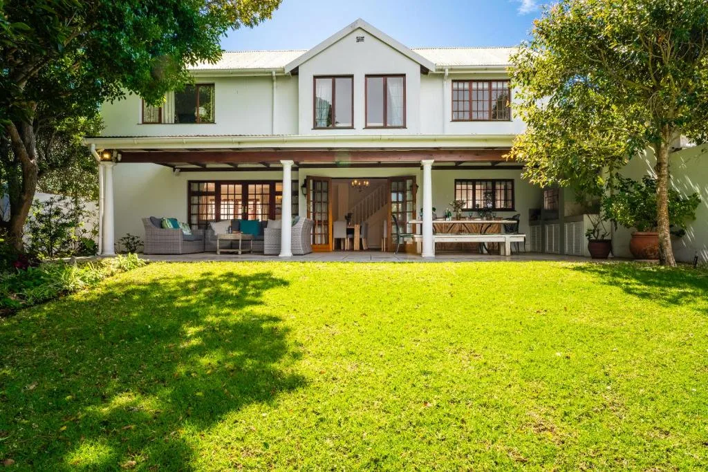 Contemporary white home with covered veranda and manicured green lawn
