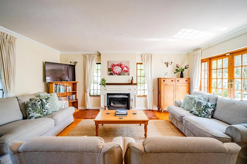 Spacious lounge with fireplace, sofas, and natural light from windows