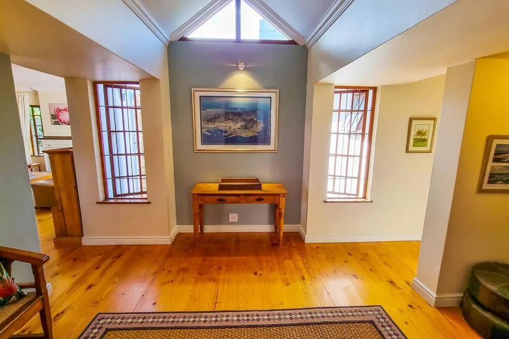 Bright lounge with wooden floors, vaulted skylight ceiling, and framed artwork