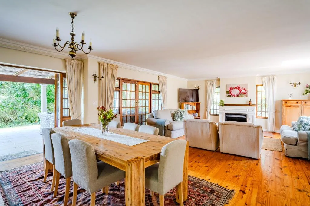 Spacious open-plan lounge with sofas, fireplace, and wooden dining table