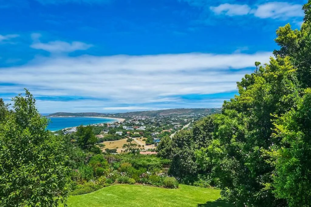Coastal town and turquoise bay nestled between green hills and ocean