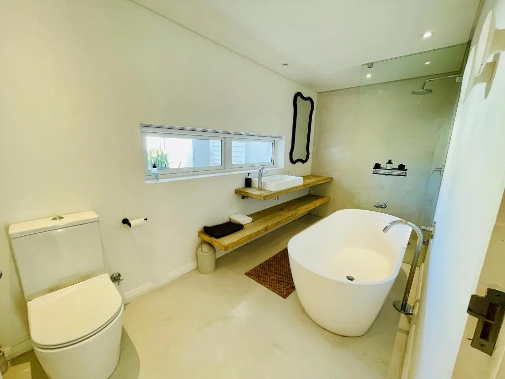 Modern bathroom with freestanding tub, wooden vanity, and rainfall shower
