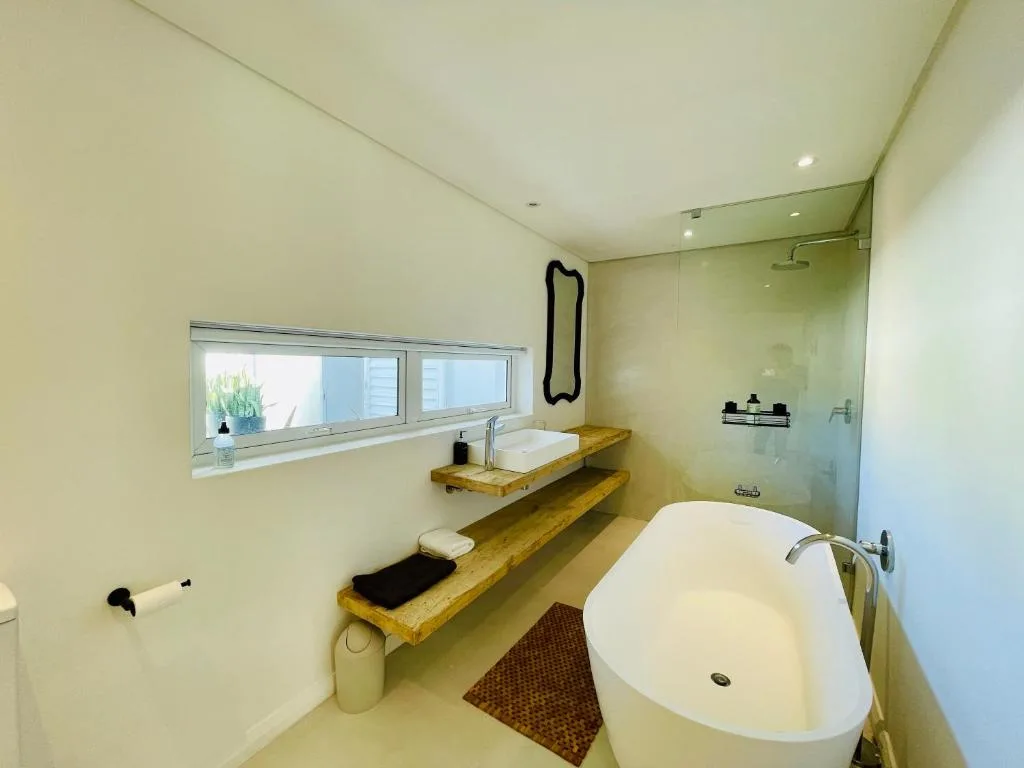 Modern bathroom with freestanding tub, wooden vanity, and walk-in shower