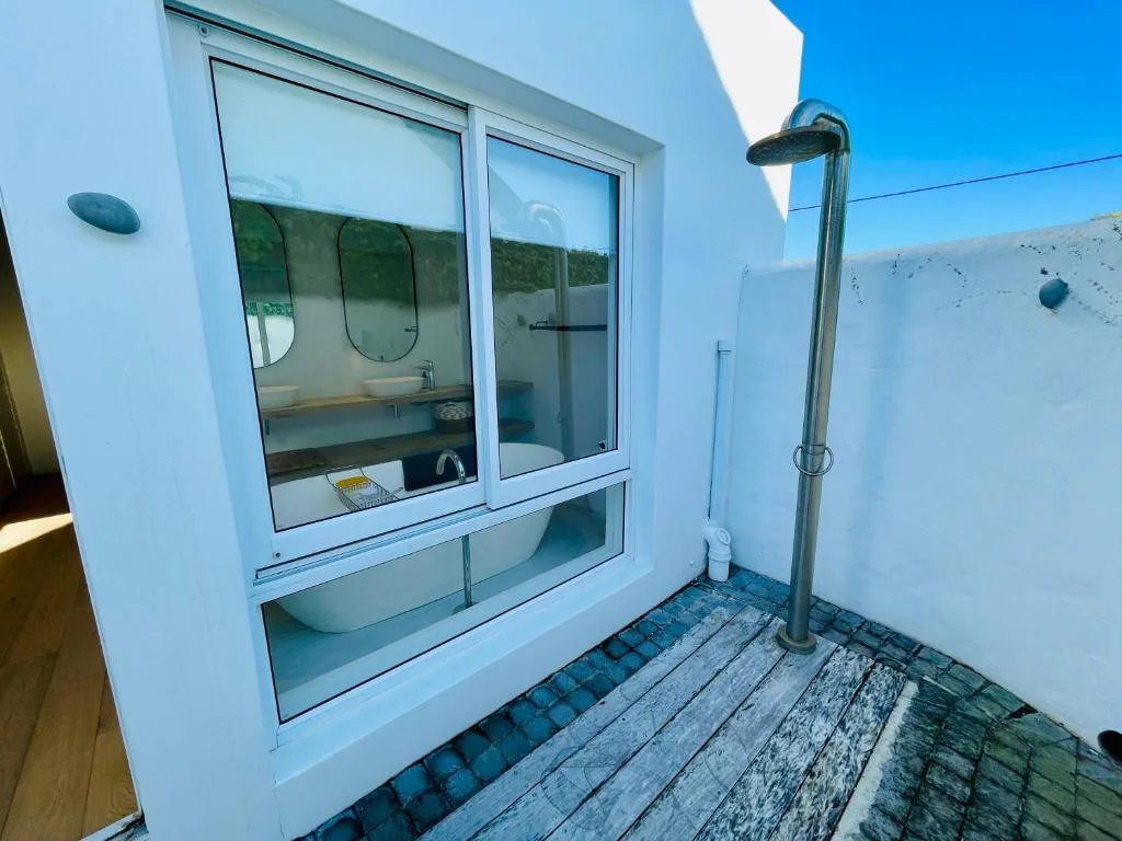 Modern outdoor shower with rainfall showerhead and vanity mirrors
