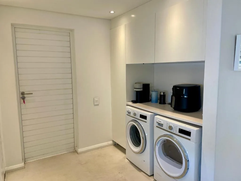 Modern laundry room with washer, dryer, and appliances on counter