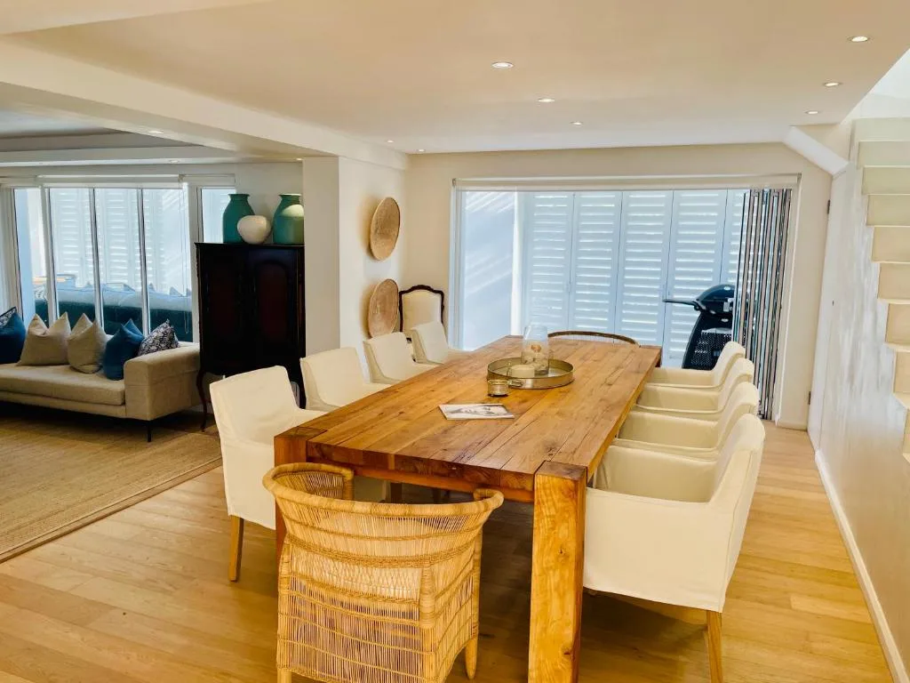 Spacious dining area with wooden table and cream upholstered chairs
