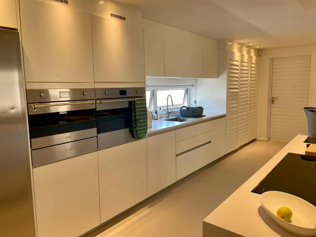 Modern white kitchen with stainless steel appliances and granite countertops