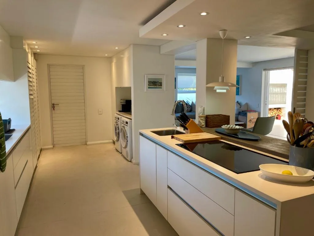 Modern kitchen with white cabinetry, black countertop, and stainless steel appliances