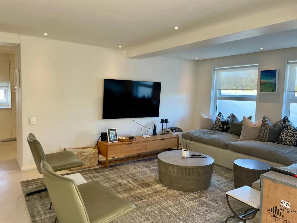 Modern living room with wall-mounted TV, comfortable seating, and ocean views