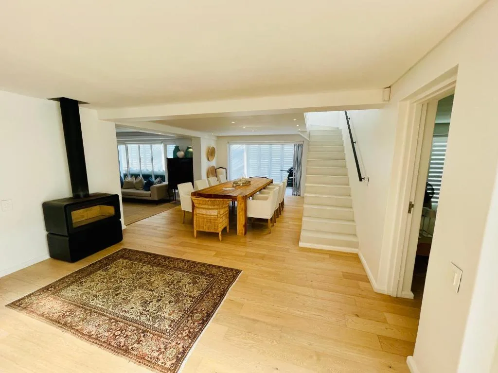 Open-plan lounge with fireplace, dining table, and wooden floors