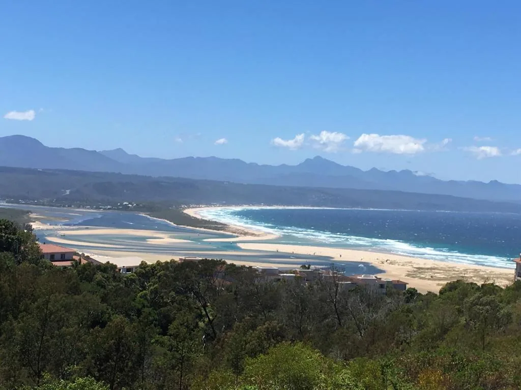 Panoramic coastal view of Plettenberg Bay with mountains, beach, and lagoon