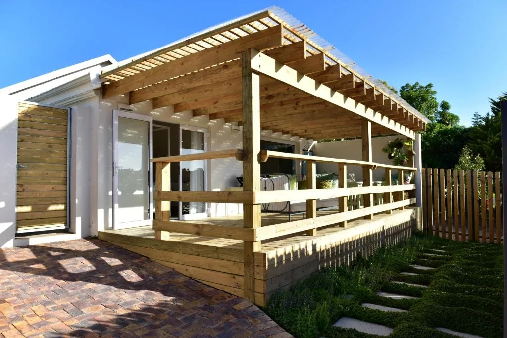 Modern wooden pergola and deck with seating areas overlooking gardens