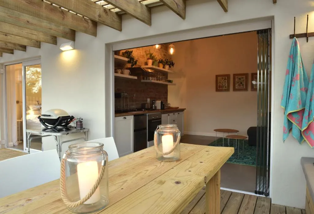Wooden dining table with candle lanterns overlooking open kitchen area