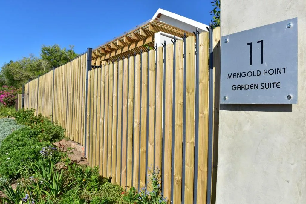 Modern wooden-clad garden suite exterior with signage and landscaped surroundings