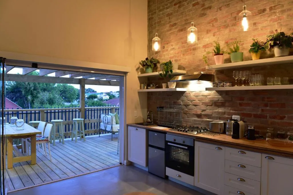 Modern kitchen with stove, wooden countertops, open shelving with plants