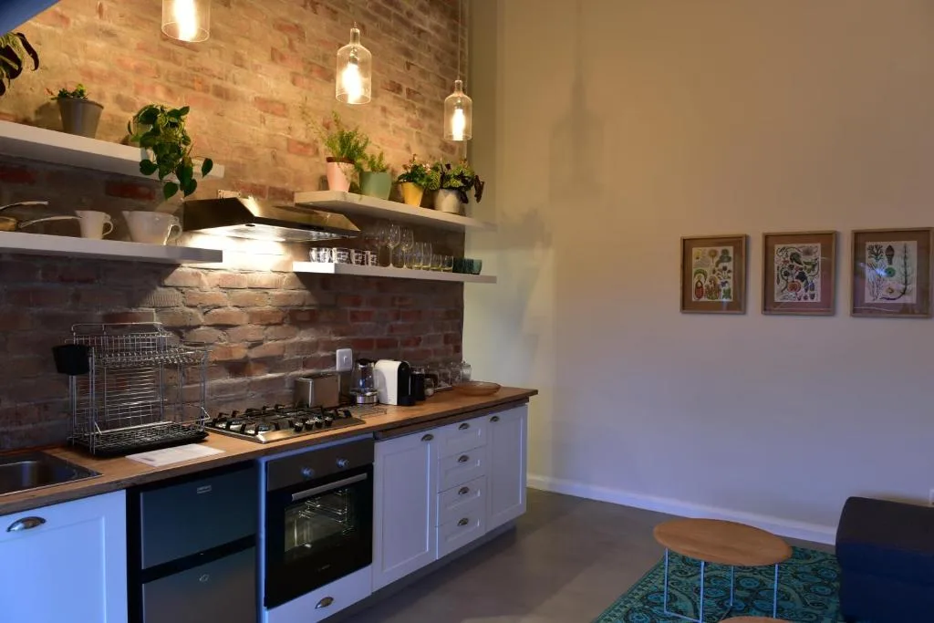 Modern kitchen with blue cabinetry, gas cooktop, and exposed brick wall