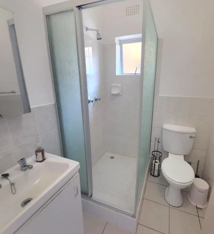 Clean bathroom with shower enclosure, toilet, and vanity sink