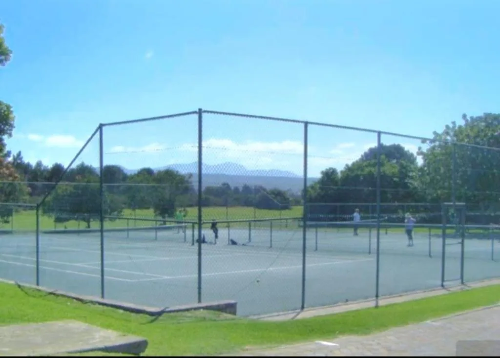 Tennis courts with mountain vista in lush garden setting