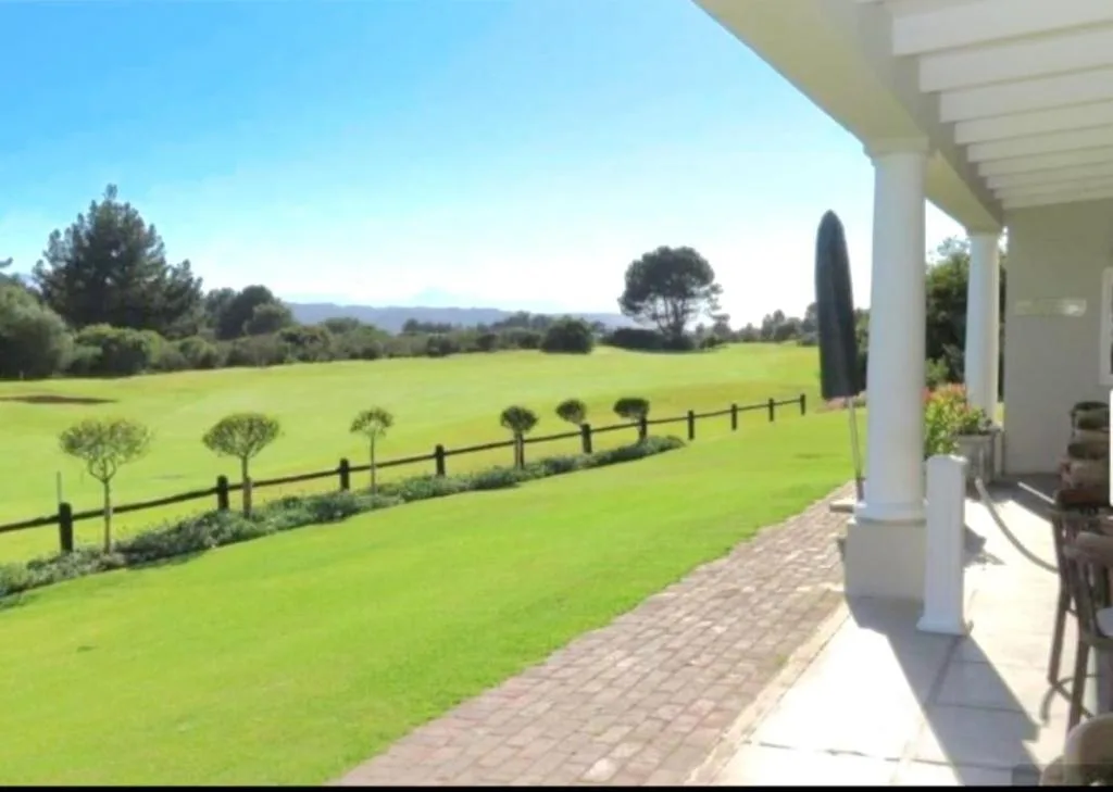 Expansive green lawns and distant mountains viewed from property deck