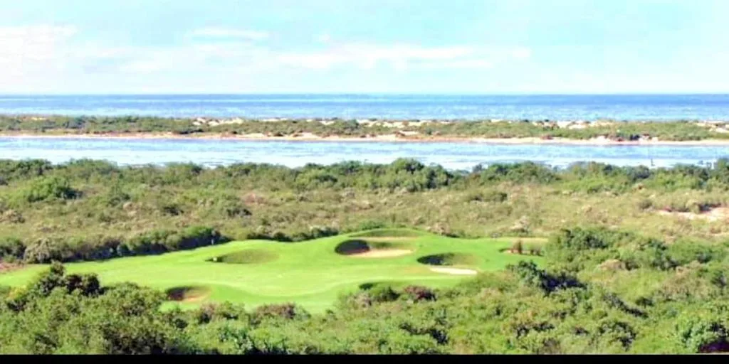 Panoramic coastal view with golf course, lagoon, and ocean beyond