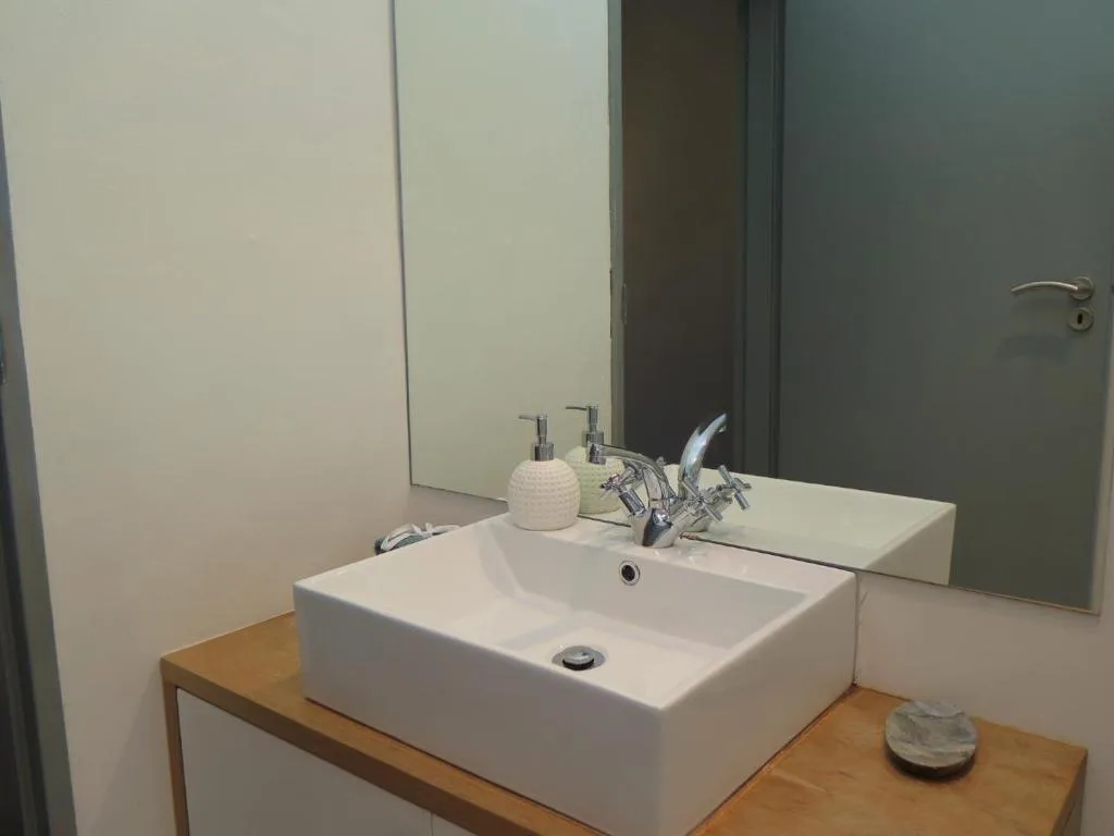 Modern bathroom vanity with white vessel sink and chrome fixtures